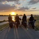 Vier Frauen auf Motorrädern vor einem Sonnenutergang